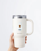 Hand holding a tumbler displaying Nuts & Lemons Co. diecut sticker featuring a polar bear chomping a brick of chocolate with the phrase “mine”