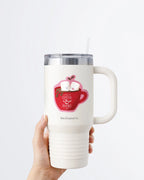 Hand holding a tumbler displaying Nuts & Lemons Co. diecut sticker featuring  a mug of hot cocoa with two marshmallows getting spicy with the phrase “I like my cocoa & books hot”