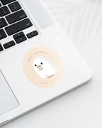 Laptop displaying a Nuts & Lemons Co. diecut sticker featuring  a cute ghostie holding a hot beverage with the phrase “cozy ghostie”