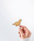 Hand holding a Nuts & Lemons Co. diecut sticker featuring a Dino nug with the phrase “you are Dino-mite”