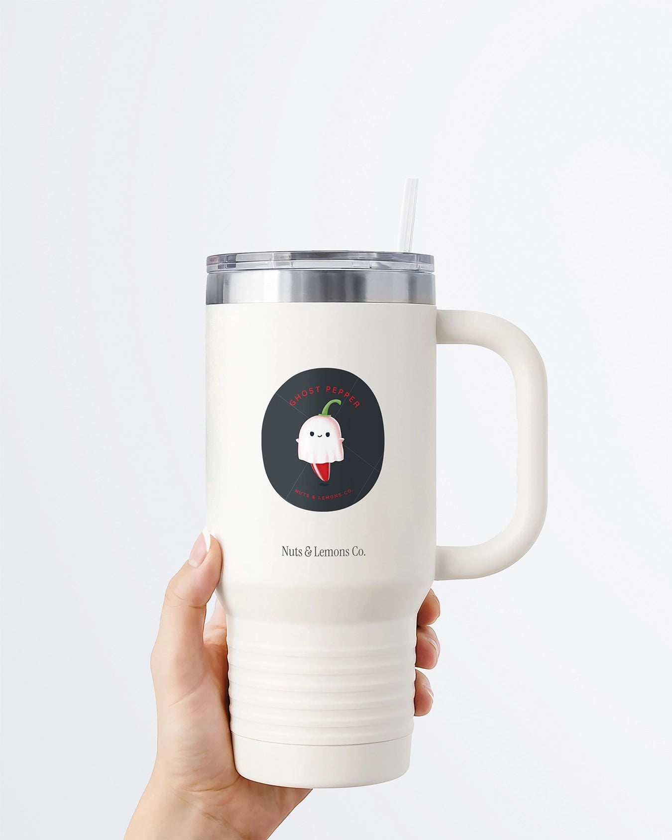 Hand holding a tumbler displaying Nuts & Lemons Co. diecut sticker featuring a cute ghost pepper dressed as a ghostie  with the phrase “ghost pepper”