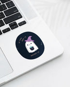 Laptop displaying a Nuts & Lemons Co. diecut sticker featuring a cute ghostie in a witch hat with a bubbling cauldron with the phrase “if you got it, haunt it”
