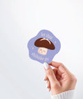 Hand holding a Nuts & Lemons Co. diecut sticker featuring a calm shiitake mushroom with the phrase “let that shiitake go”