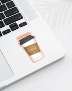Laptop displaying a  Nuts & Lemons Co. diecut sticker featuring a togo coffee with the phrase “love yourself like you love your coffee”