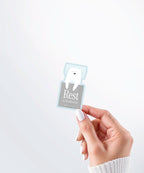 Hand holding a Nuts & Lemons Co. diecut sticker featuring sleeping polar bear with the phrase “rest is productive”