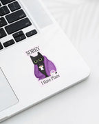 Laptop with a Nuts & Lemons Co. diecut sticker featuring a black cat in a starry blanket holding a mug and crystals with the phrase “Sorry I Have Plans”
