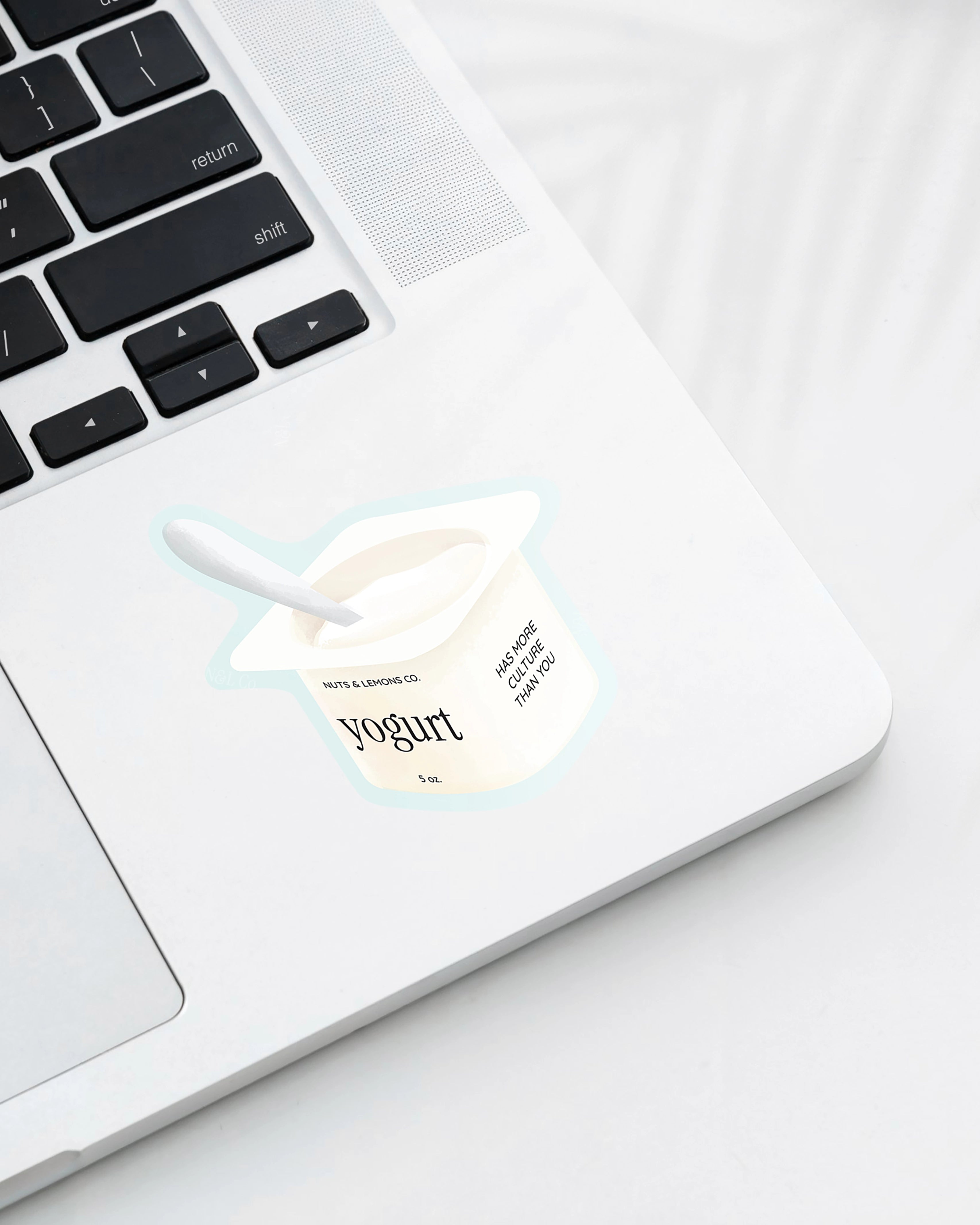 Laptop with a Nuts & Lemons Co. diecut sticker featuring a yogurt cup with the phrase “Yogurt Has More Culture”